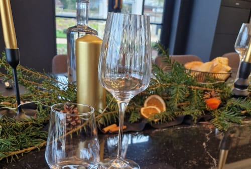 Élégante mise de table au B&B Le Paradis de Lucile à La Roche Guyon avec verres à vin, chandelle dorée et verdure