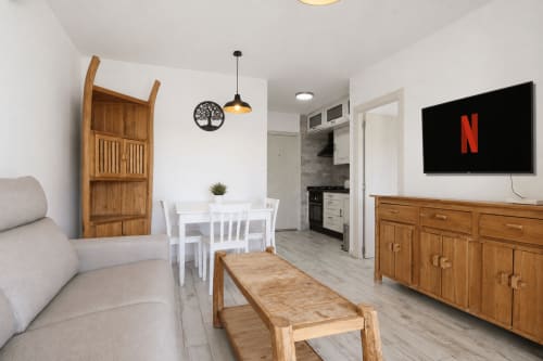 Sala de estar moderna en Riurau Home Calpe con muebles de madera, comedor, Netflix y acceso a vistas al mar