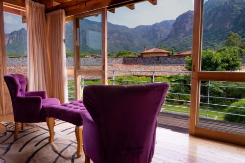 Purple velvet armchairs on terrace overlooking Tepoztlán mountains at La Hacienda hotel