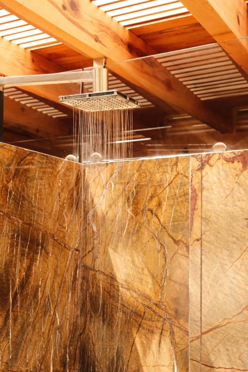Luxury rainfall showerhead in Master Suite at La Hacienda Tepoztlán with natural wood beams and marble walls