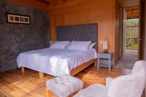 Junior Suite bedroom at La Hacienda Tepoztlan with garden views, wooden floors, and modern furnishings