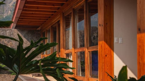 Deluxe Suite terrace at La Hacienda Tepoztlán with wooden doors, mountain views, and garden plants in Tepoztlán, Mexico