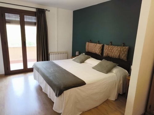 Habitación doble con balcón privado en el hotel El Balco del Priorat de Tarragona, con pared de acento verde oscuro y decoración moderna