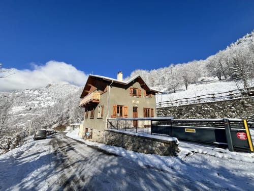 Chalet école des Cîmes à Bozel enneigé, France, avec chaîne montagneuse et ciel bleu dégagé