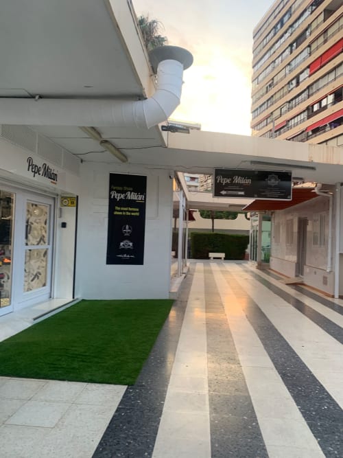 Fachada del restaurante Pepe Milán con frente blanco y césped artificial en Benidorm, España, parte de Milan Soria Luxury