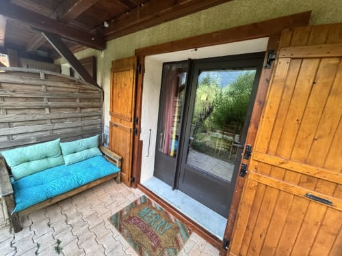 Entrée de patio couvert avec banc rembourré bleu à l'appartement La Guisane, Chalets La Caillaude, La Salle-les-Alpes