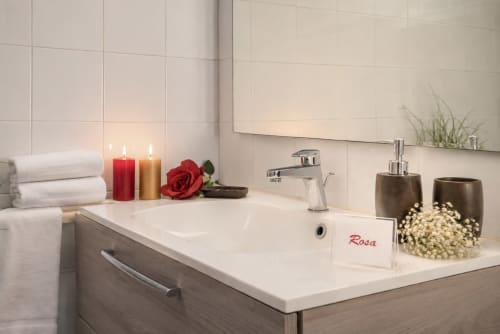 Elegant bathroom sink in Rosa room at I colori della Sicilia B&B, Caltagirone with candles and rose décor
