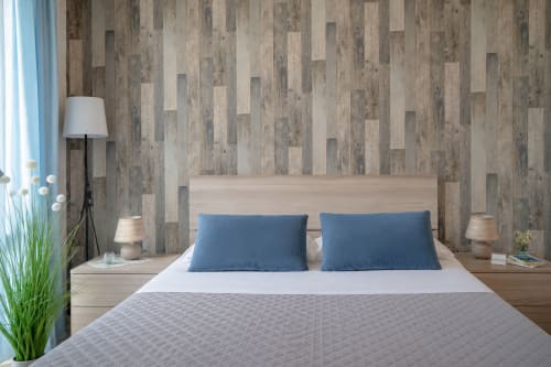 Modern bedroom at I colori della Sicilia in Caltagirone with wood-plank walls, light wood bed, blue pillows, and contemporary