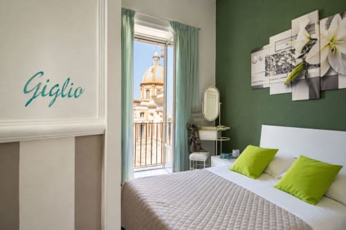 Camera Giglio a I colori della Sicilia B&B di Caltagirone con parete accent verde, cuscini lime e vista balcone sul centro storico