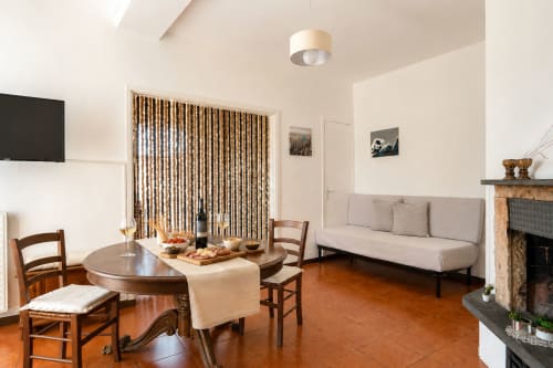 Soggiorno dell'appartamento La Tegola con tavolo da pranzo, camino e vista sui monumenti di Caltagirone, Sicilia