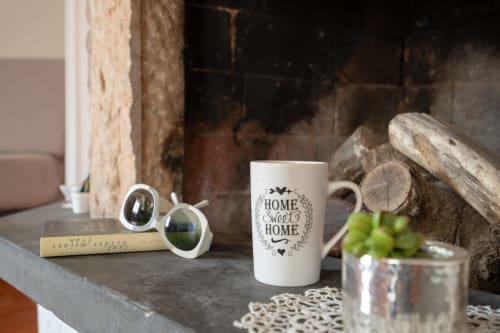 Arredamento rustico a La Tegola con tazza 'Home Sweet Home', legno di mare e mele verdi su ripiano in pietra