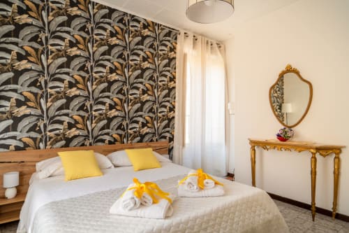 La camera La Tegola presso I colori della Sicilia a Caltagirone con testata letto decorata, cuscini gialli e specchio dorato