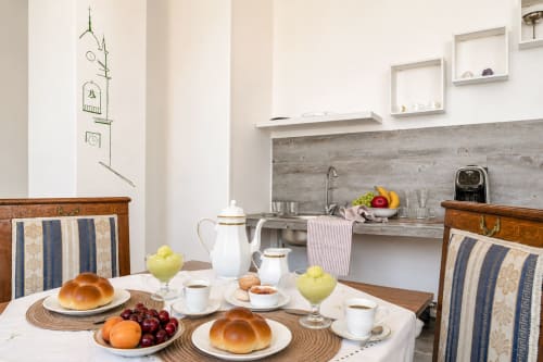 Elegante allestimento da tavola all'appartamento Il Campanile di Caltagirone con panini, frutta fresca e servizio di tè