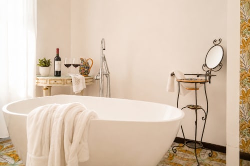 Elegante vasca da bagno indipendente con asciugamani bianchi nella suite Il Campanile di I colori della Sicilia B&B, Caltagirone Sicilia