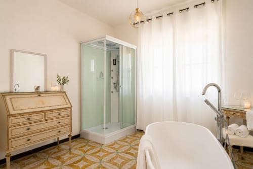 Lussuoso bagno dell'appartamento Il Campanile a Caltagirone con vasca freestanding, doccia, vanità in legno e piastrelle geometriche