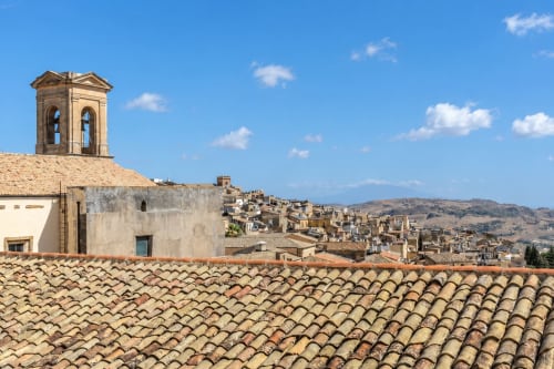Vista sui tetti di Caltagirone con campanile e architettura storica del villaggio siciliano sulle colline