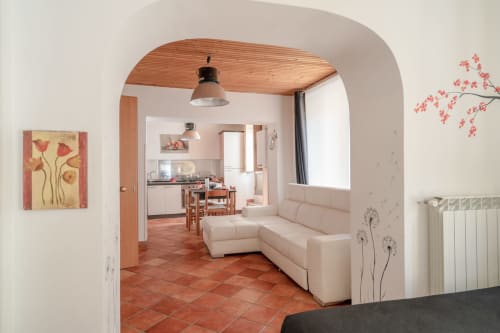 Luminoso appartamento open space a I colori della Sicilia a Caltagirone con divano color crema, piastrelle in terracotta e vista sulla cucina