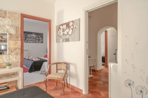 Superior apartment bedroom at I colori della Sicilia in Caltagirone, Sicily with terracotta floors and floral artwork