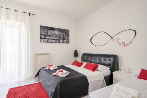 Modern bedroom in Il sogno Superior at I colori della Sicilia B&B, Caltagirone, with black upholstered bed, red accents, and