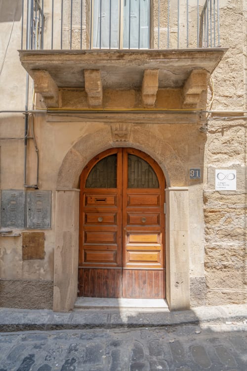 Historic wooden arched door with number 81, Caltagirone Sicily landmark entrance to I colori della Sicilia bed and breakfast