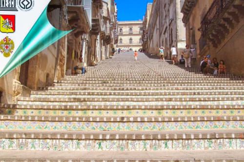Colorful ceramic steps in historic Caltagirone street leading to baroque square with traditional architecture