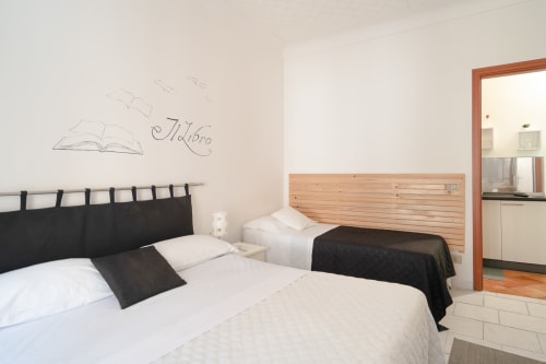 Modern bedroom at I colori della Sicilia in Caltagirone with two beds, wooden headboard, and wall art