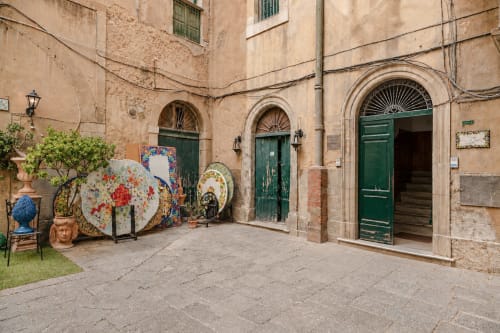 Sicilian courtyard at I colori della Sicilia in Caltagirone with colorful ceramic art, green doors, and traditional stone