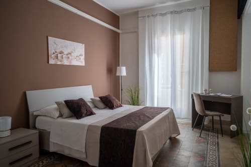 Modern bedroom in Diamante room at I colori della Sicilia B&B in Caltagirone, Sicily with terracotta accent wall and city