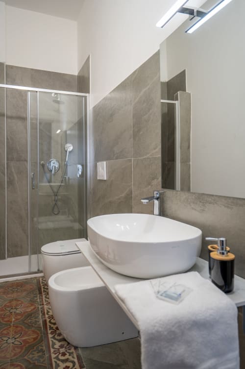 Modern bathroom in Diamante room at I colori della Sicilia B&B, Caltagirone, featuring white oval bathtub, glass shower,
