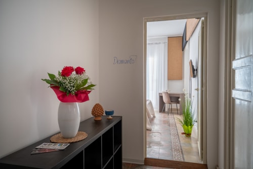 Diamante room at I colori della Sicilia in Caltagirone with red roses and entrance to hallway