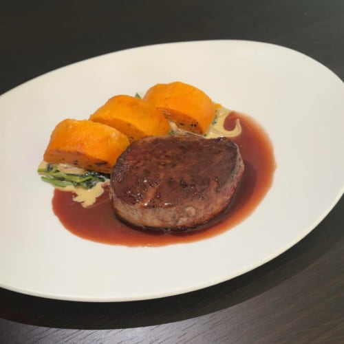 Seared beef fillet with red wine reduction and roasted carrot garnish on white plate at Sliabh Beagh Hotel, Monaghan