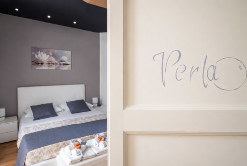 Ingresso della suite Perla presso I colori della Sicilia a Caltagirone con porta decorata e vista della camera da letto