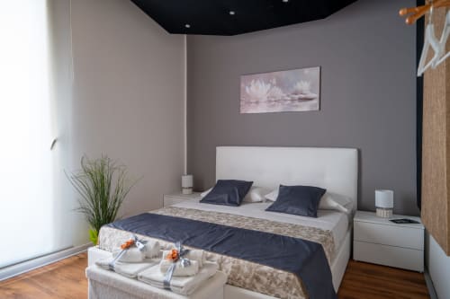 Modern bedroom at Perla room, I colori della Sicilia B&B in Caltagirone, Sicily with white bed, navy pillows, and city view