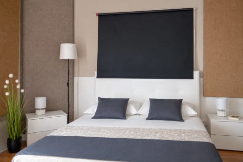 Modern bedroom at I Colori della Sicilia in Caltagirone with white bed, dark headboard, navy pillows, and minimalist decor