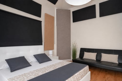 Modern bedroom at I colori della Sicilia in Caltagirone with bed, black accents, sofa, wooden floors and garden view