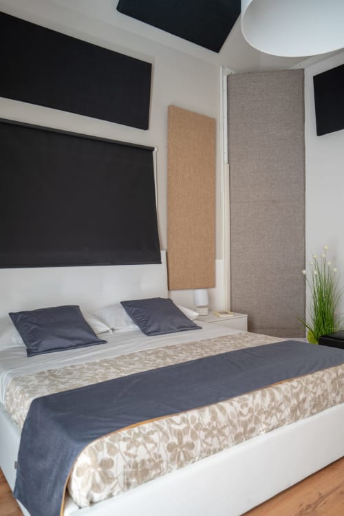 Modern bedroom at I colori della Sicilia B&B in Caltagirone with queen bed, dark bedding, wall-mounted TV, and neutral decor