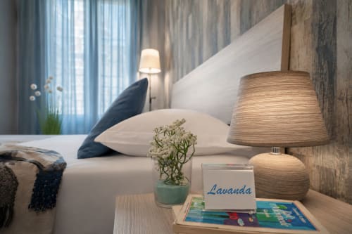 Camera moderna presso I colori della Sicilia B&B a Caltagirone con cuscini bianchi, lampada in legno e decorazioni lavanda