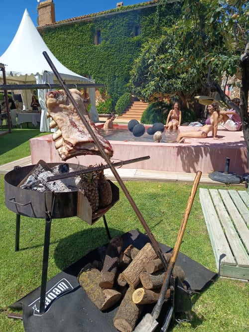 Rassemblement en plein air au jardin de la maison Costa Brava avec barbecue à bois, espace détente et bâtiment recouvert de lierre
