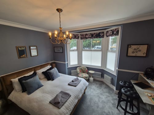 Elegantly decorated king bedroom at Baschurch House Shrewsbury with garden views, chandelier, and modern amenities