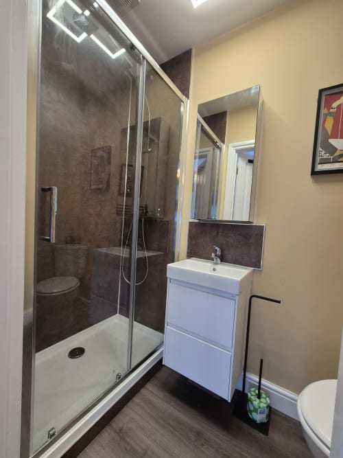 Modern bathroom with walk-in shower, white vanity sink, and mirror at Baschurch House boutique hotel in Shrewsbury