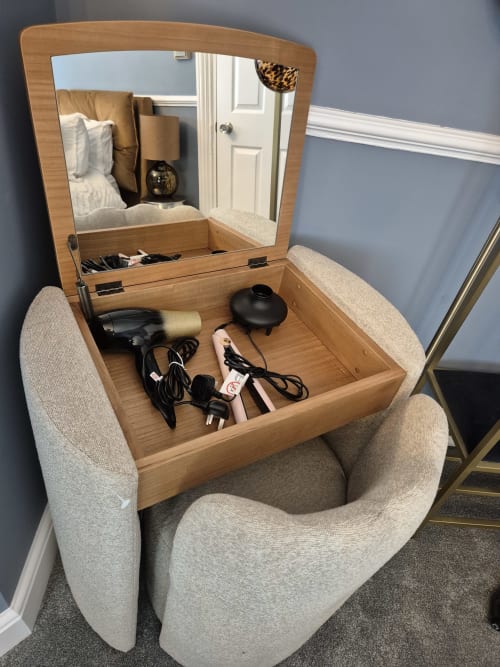 Wooden vanity desk with mirror and storage drawer containing hairdryer and accessories at Baschurch House boutique hotel in