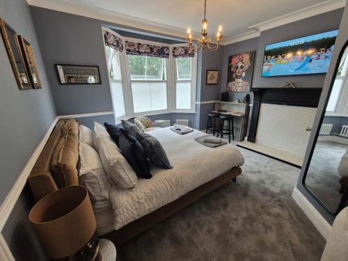 Luxurious king bedroom at Baschurch House Shrewsbury with grey walls, garden views, TV, and modern amenities