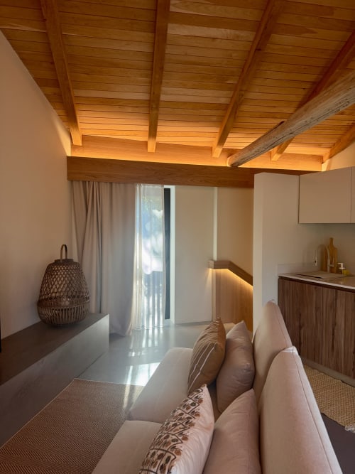 Modern villa bedroom at Quinta Das Pirâmides with wooden beamed ceiling, cream sofa, mountain views, and contemporary design