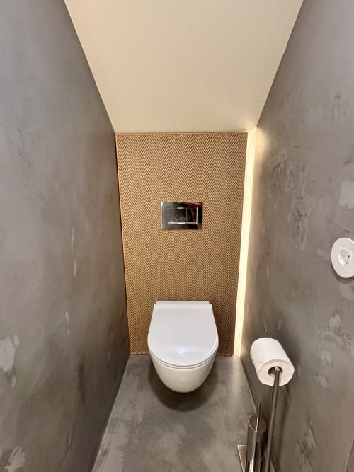 Modern bathroom toilet with herringbone tile accent wall at Quinta Das Pirâmides villa in Vila Nova de Famalicão