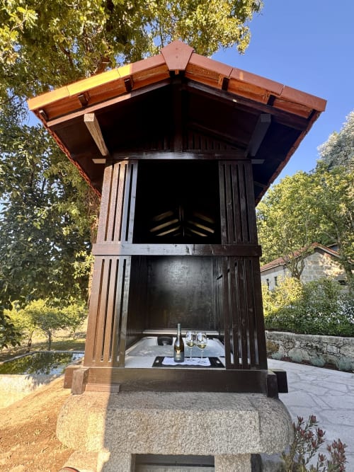 Wooden pavilion at Quinta Das Pirâmides in Vila Nova de Famalicão with wine bottle and glasses inside rustic Celeiro villa