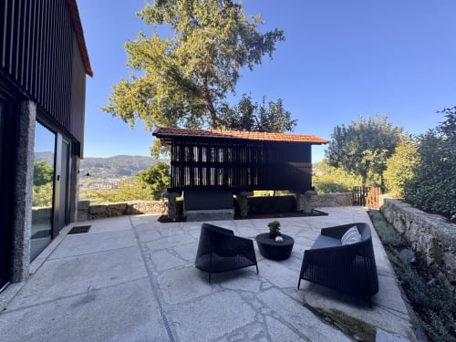 Celeiro villa at Quinta Das Pirâmides with terrace, black seating, mountain views, and traditional building in Vila Nova de