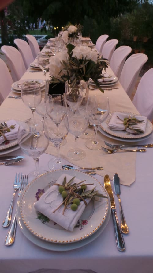 Table élégante dressée en extérieur à la Clos Bb en Saint-Cyr sur Mer, décorée de cartes de place aux branches d'olivier