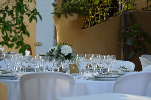 Élégante mise en place en terrasse au Clos Bb à Saint-Cyr-sur-Mer avec table blanche, verres et composition florale blanche