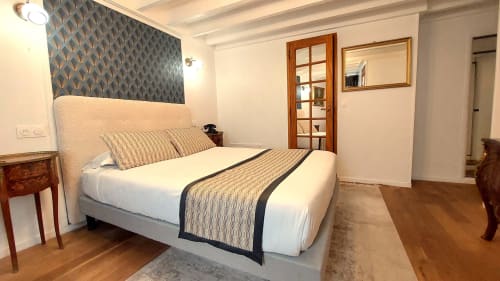 Chambre moderne de l'Hôtel Dandy à Rouen avec lit queen-size, tête de lit motif, portes en bois et vue sur la ville