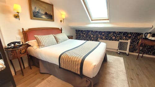 Chambre mansardée à l'Hôtel Dandy Rouen avec lit double, plafond en pente, lucarne et vue sur la ville